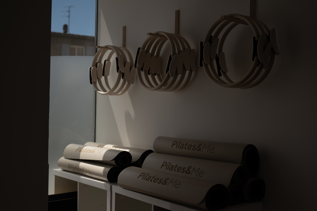Tapis de Pilates enroulés rangés sur une étagère du studio LOUMA, accessoires pour les séances au sol