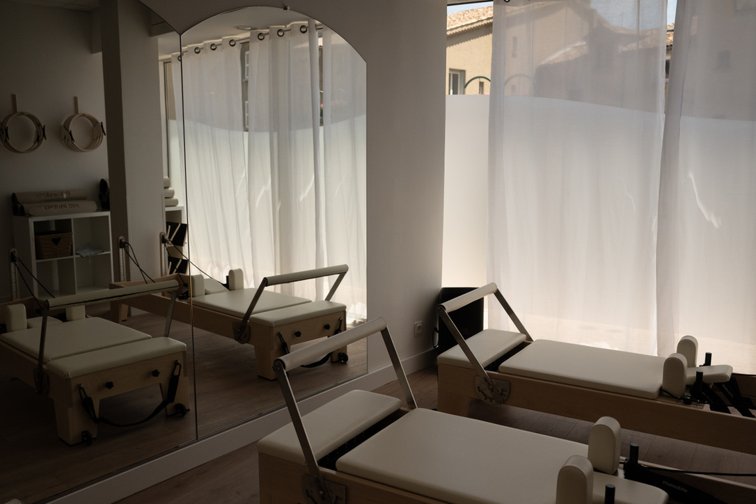 Reformer devant une grande fenêtre voilée du studio LOUMA, lumière naturelle douce
