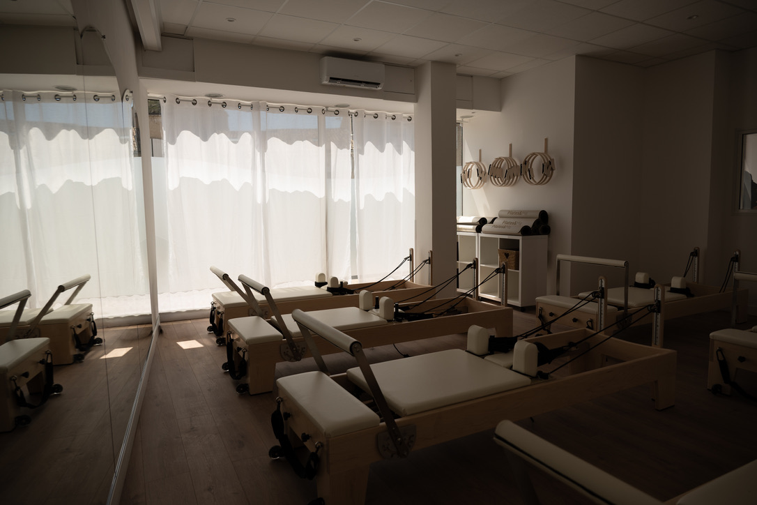 Vue panoramique du studio LOUMA Pilates à Sisteron, reformers alignés et grandes fenêtres habillées de voilages
